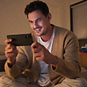 Imagine cu o persoană ascultând la Xperia 5 V cu o pereche de căști albe și cântând cu muzica