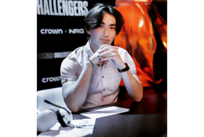 Imagen de ethos, de NRG, sentado en una mesa con un poster de fondo y unos audífonos con micrófono INZONE H9 sobre la mesa