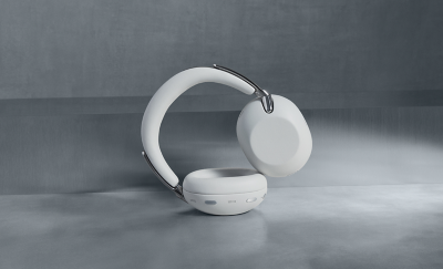 A pair of white 1000X THE COLLEXION headphones on their side against a dark grey background