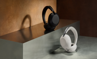Two sets of 1000X THE COLLEXION headphones, one black and one white, on some dark grey stone steps