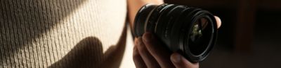 View of lens barrel held in user’s hand, showing the compact lens size