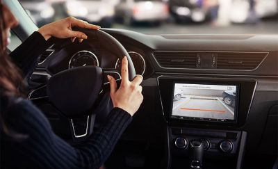 Nuotrauka – asmuo stato automobilį, naudodamasis XAV-AX4050 atbulinės eigos kamera.