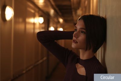 Near-profile close-up portrait of woman looking left in ship hallway with significant background bokeh