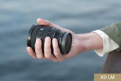 View of lens barrel held in user’s hand, emphasising compact size of the lens