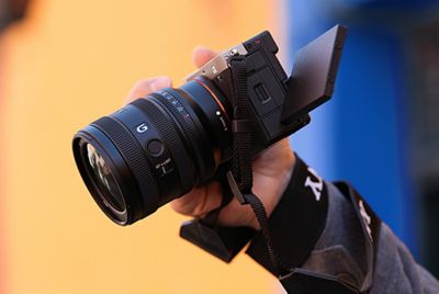 Hình ảnh cách sử dụng chụp từ trên cao người dùng cầm máy ảnh α7CII có ống kính FE 24-50 mm F2.8 G, cho thấy kích thước nhỏ gọn của ống kính