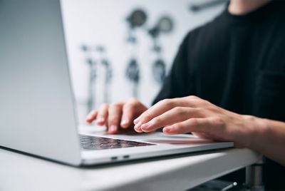 صورة شخص يكتب على كمبيوتر محمول