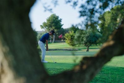 Hình ảnh ví dụ một người chơi golf được lấy nét, còn thân cây được làm mờ ở tiền cảnh