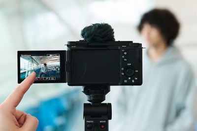 Hình ảnh ngón tay chạm vào màn hình cảm ứng của máy ảnh