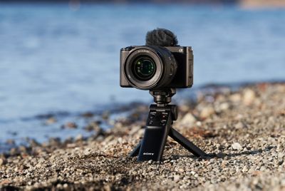 Image of a camera near a river, with a grip attached and used as a tripod