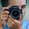 Photo of a photographer looking through the viewfinder while shooting still photos