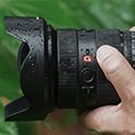 תמונה של איש מחזיק את מצלמת α7R V בזמן שפני השטח שלה רטובים