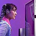 Sėdinčio prie monitoriaus žaidėjo vaizdas: ausyse – dedamos į ausį ausinės „INZONE Buds“.