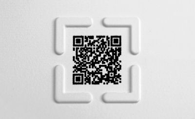 QR code printed on paper with a raised tactile border around it.