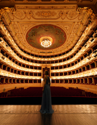 Una mujer con un vestido largo azul parada en un escenario frente a un teatro vacío.