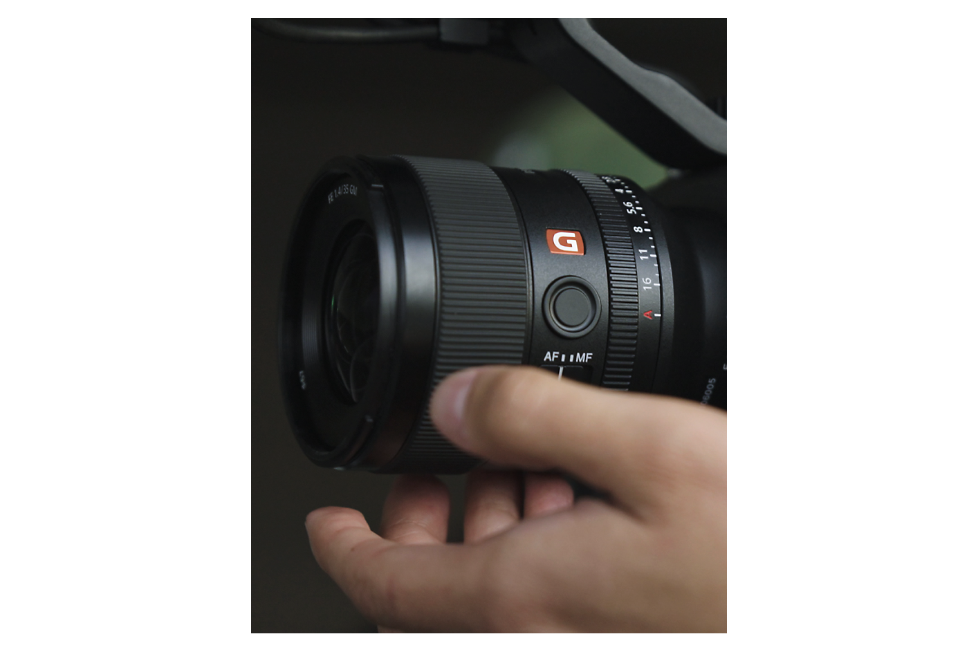 Una mano ajustando un lente con montura tipo E Sony G Master