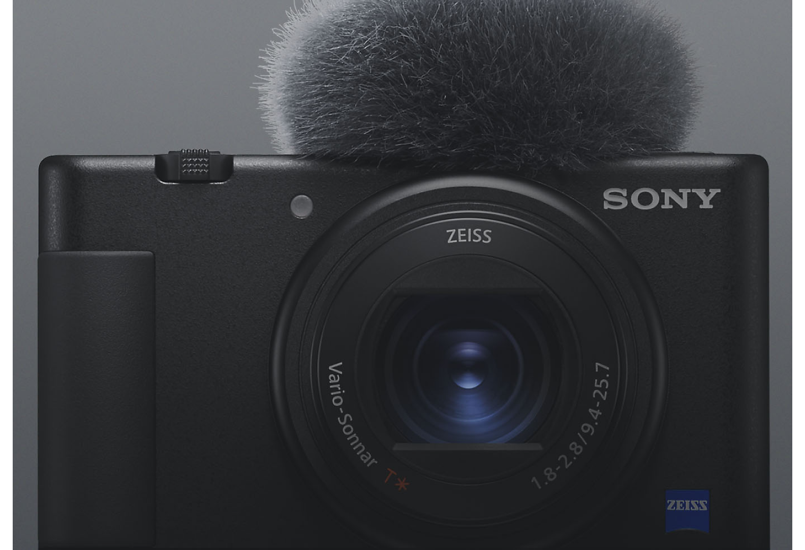 Pohled zepředu na černý kompaktní fotoaparát Sony s připevněným mikrofonem