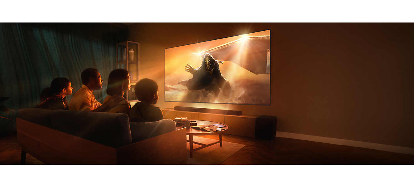 סצנת סלון עם ארבעה אנשים שיושבים על ספה, טלוויזיה המותקנת על קיר ומקרן קול, עם צילום מסך של אסטרונאוט צועד דרך ערפל כתום