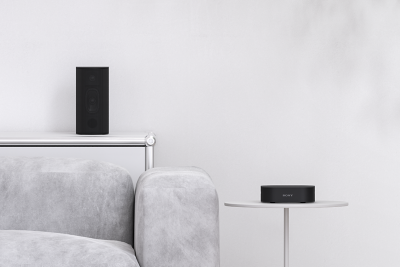 Enceinte arrière et boîtier de commande posés sur une table.