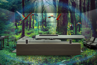 Näkymä kotiteatterista, jossa kaiuttimista lähtee mukaansatempaavaa ääntä ja TV-ruudulla näkyy eloisa metsäaiheinen kuva