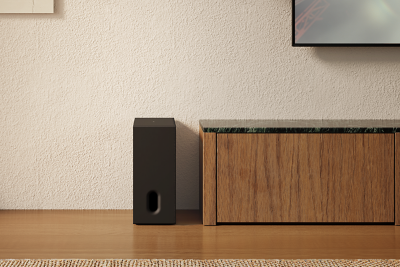 Caisson de basses placé à la verticale à côté d'un meuble bas dans un salon