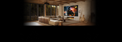 Living room scene showing Sony Projector mounted on the ceiling projecting a scene onto the wall showing a motorbike racing on the street at night