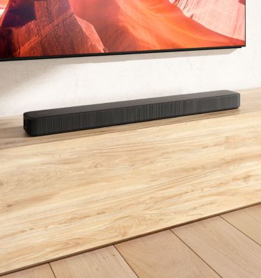 Abbildung der HT-S2000 Soundbar, die auf einem Fernsehschrank aus Holz steht