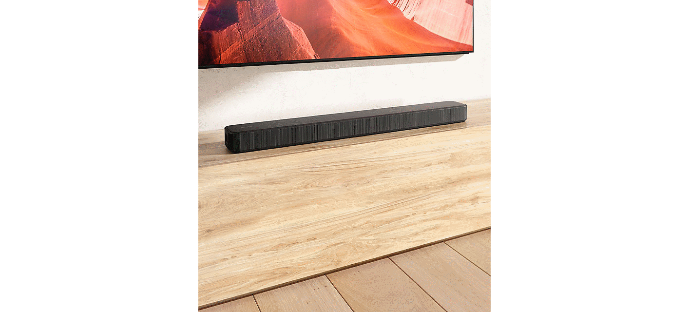 Imagem da barra de som HT-S2000 colocada sobre uma mesa de televisão em madeira