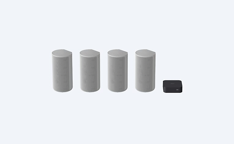Image of four gray speakers and a black control box