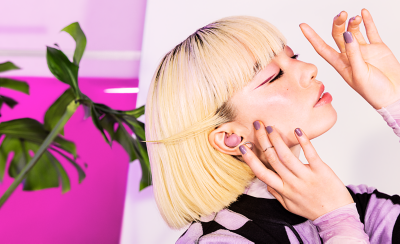 Một người sành điệu đang đeo cặp tai nghe màu hồng.