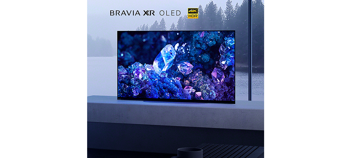 BRAVIA A90K on marble platform in living room with image of blue and purple crystals on screen