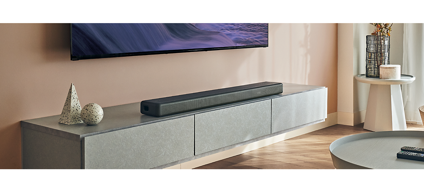 A bright, contemporary living room featuring an HT-A3000 soundbar positioned underneath a wall-mounted BRAVIA TV