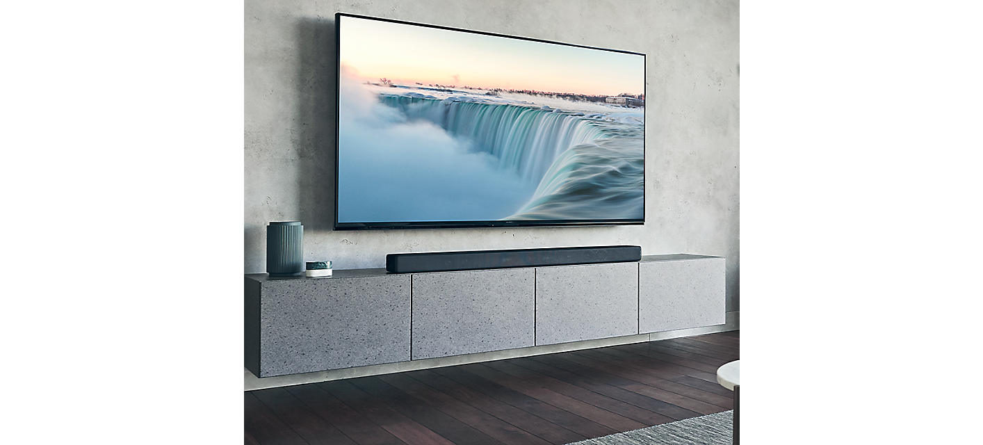 HT-A7000 Soundbar onder een grote tv op een marmeren dressoir in een woonkamer