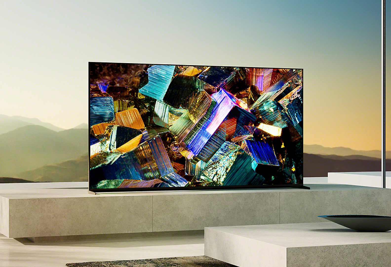 大理石底座上的 BRAVIA Z9K 位於客廳，螢幕上呈現繽紛金屬箔盒的影像