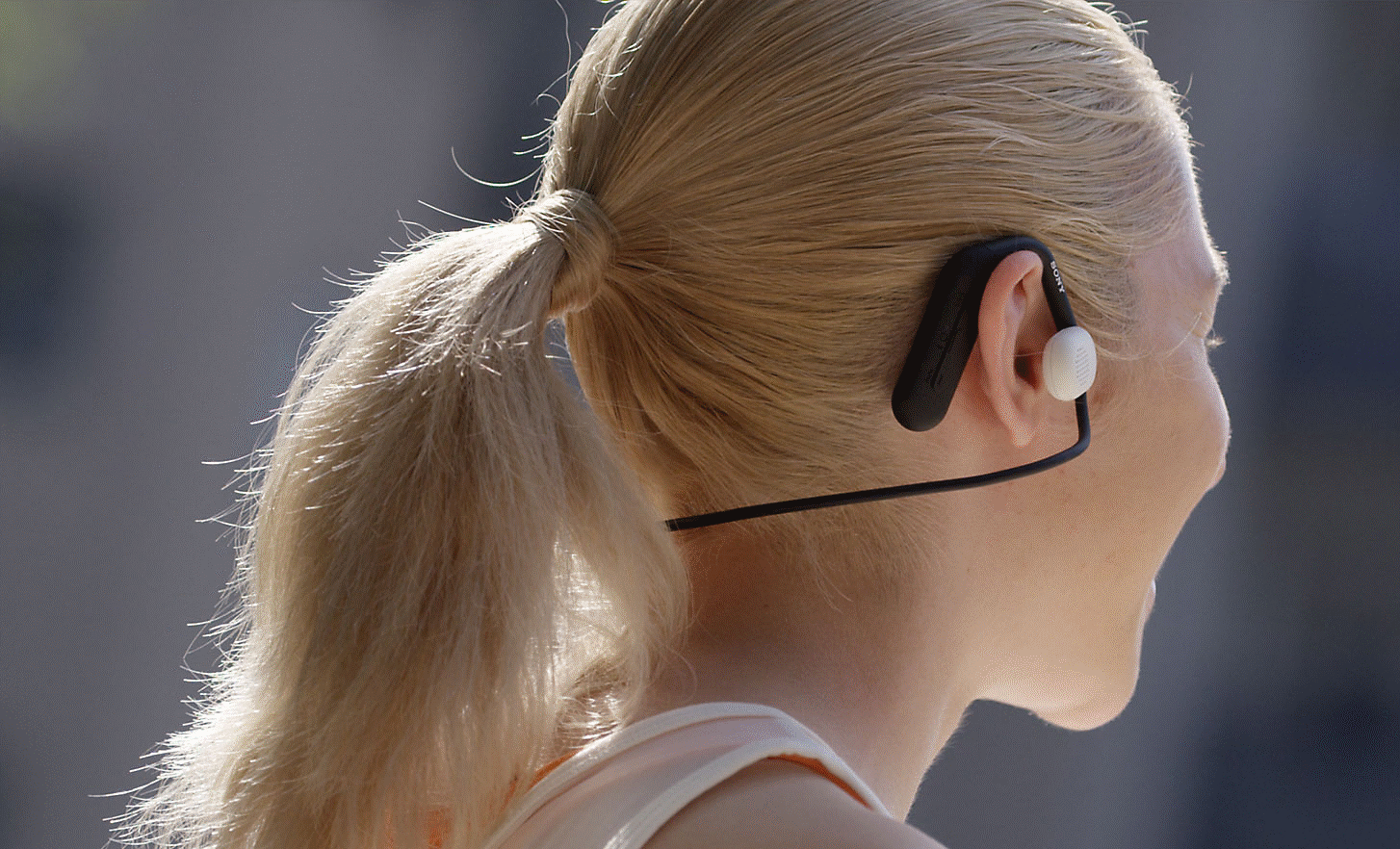 Image of a woman wearing Sony Float Run headphones taken from behind