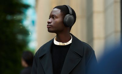 Un hombre lleva unos auriculares WH-CH730N de Sony en negro en la calle de una ciudad