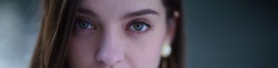 Close-up facial portrait of female model, with resolution of subject standing out against bokeh