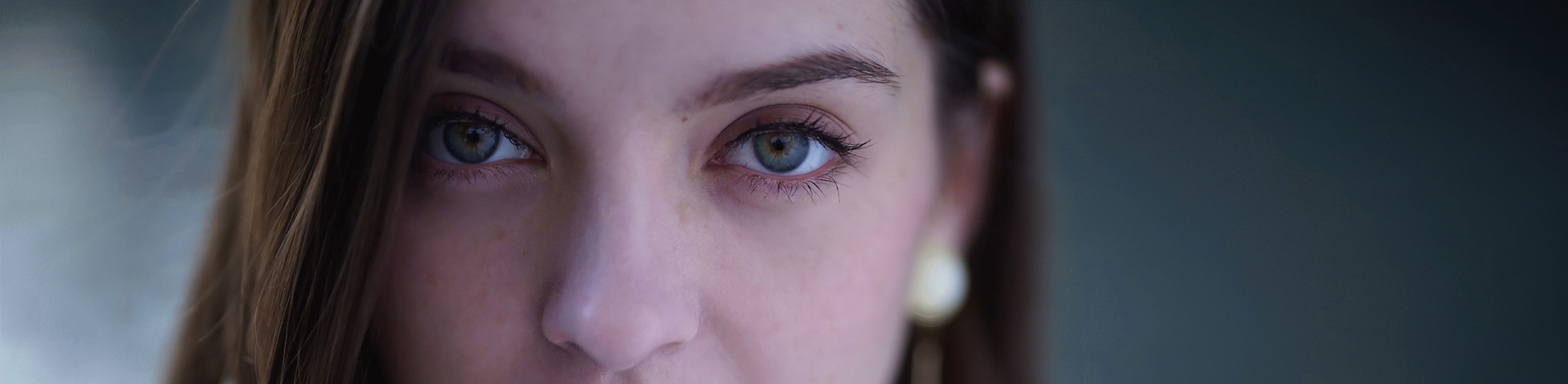 Close-up facial portrait of female model, with resolution of subject standing out against bokeh
