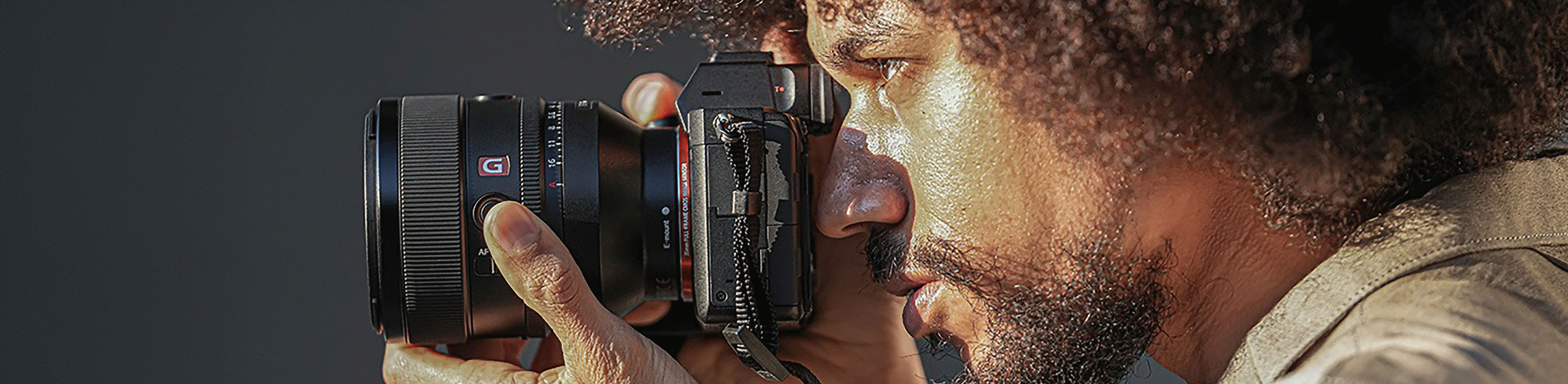 Afbeelding van een persoon die een camera vasthoudt waarop de FE 50 mm F1.2 GM-lens is bevestigd