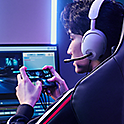 A pro gamer wearing a headset, playing on Xperia 1 IV Gaming Edition connected to two monitors
