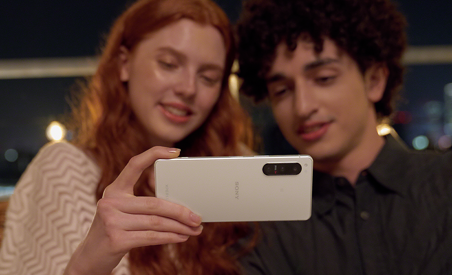 Žena a muž, ktorí sa spolu pozerajú na obsah v smartfóne Xperia 5 IV