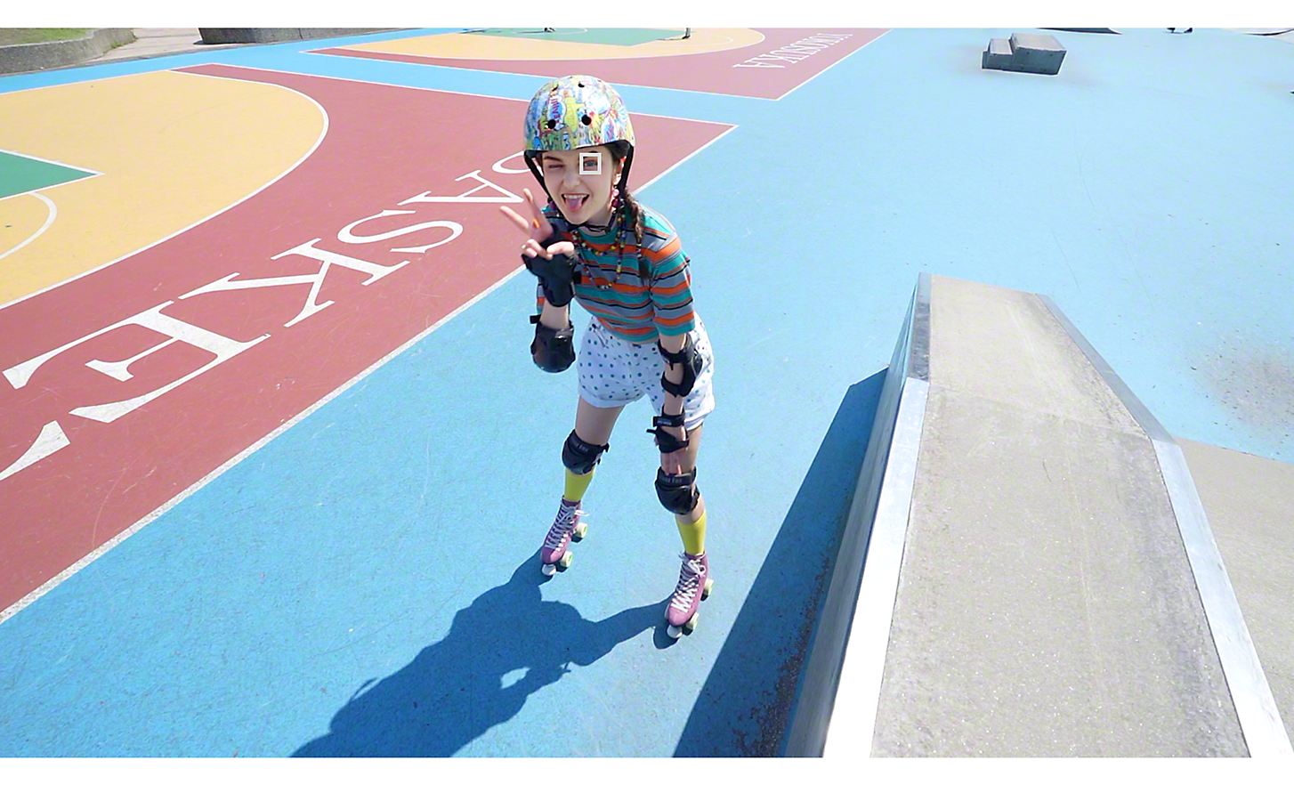 Portrait of a female roller skater at a skate park, a white square over her eye denoting Eye AF for video