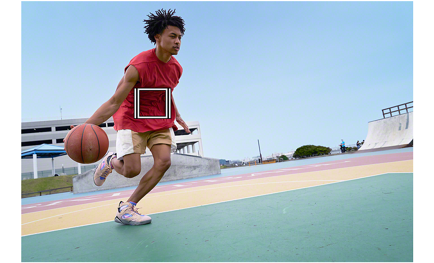 一位男士正控著籃球，畫面出現標示物件追蹤功能的白色正方形