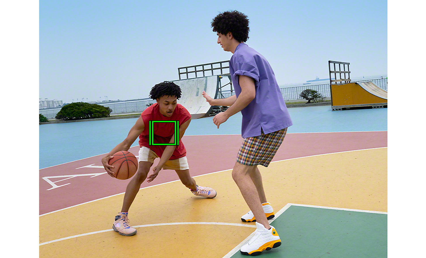 A one-on-one basketball game, a green square denoting Real-time Tracking