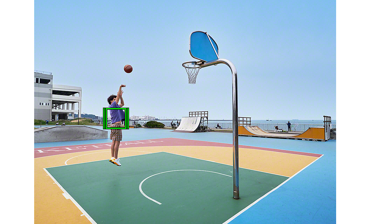 Un basketteur en plein saut pour tirer, un carré vert qui représente le suivi en temps réel