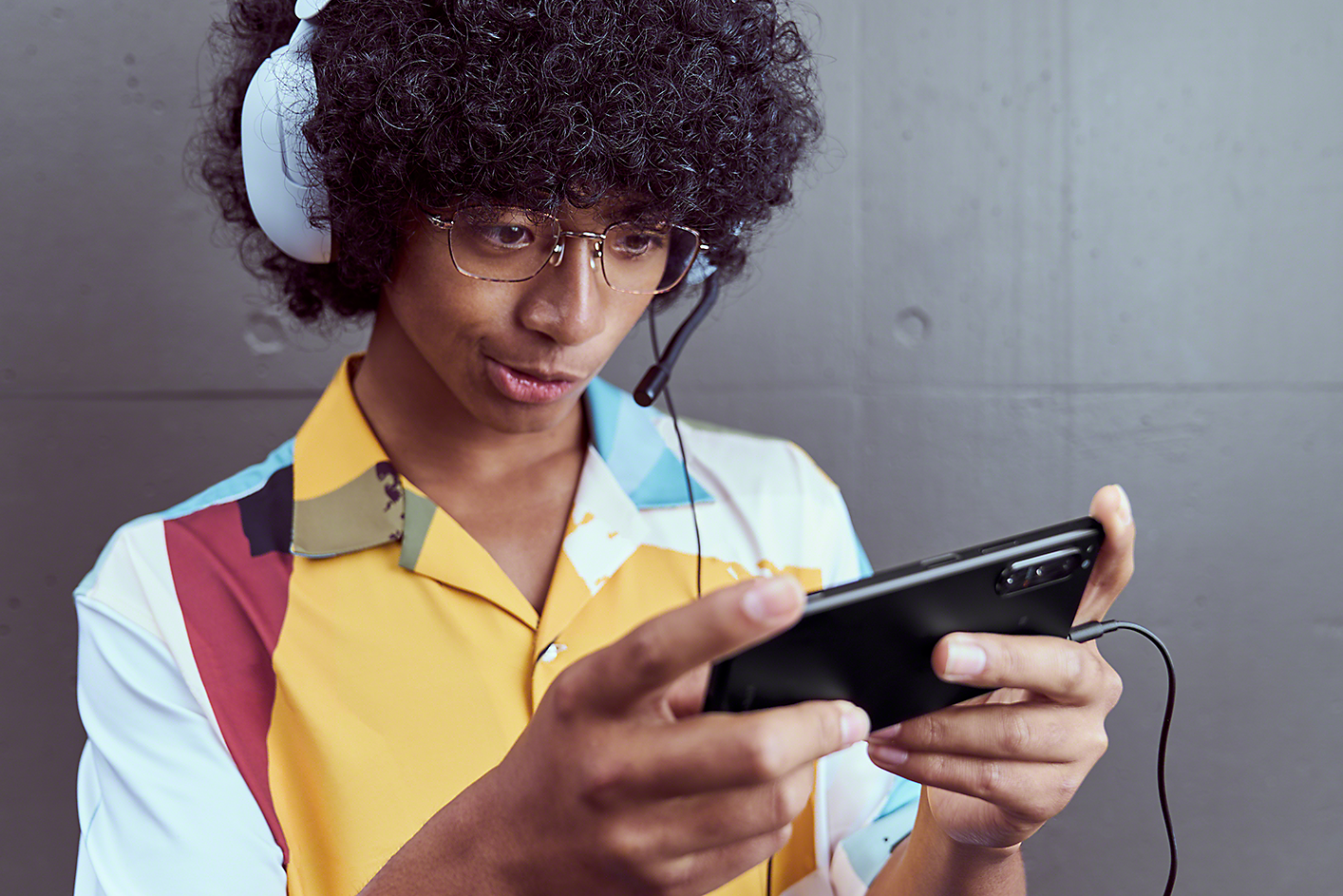 Ung mann med gaminghodesett som spiller på Xperia 5 IV