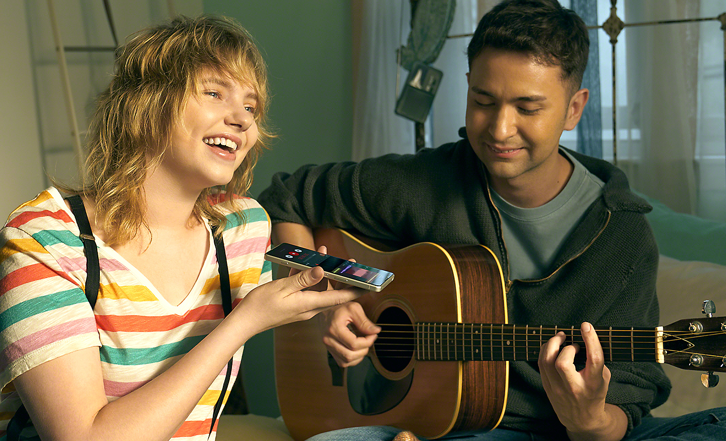 Moški igra na kitaro in ženska uporablja telefon Xperia 5 IV za snemanje glasbe