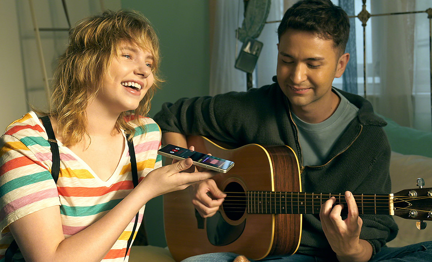 Muž hraje na kytaru a žena nahrává hudbu pomocí telefonu Xperia 5 IV