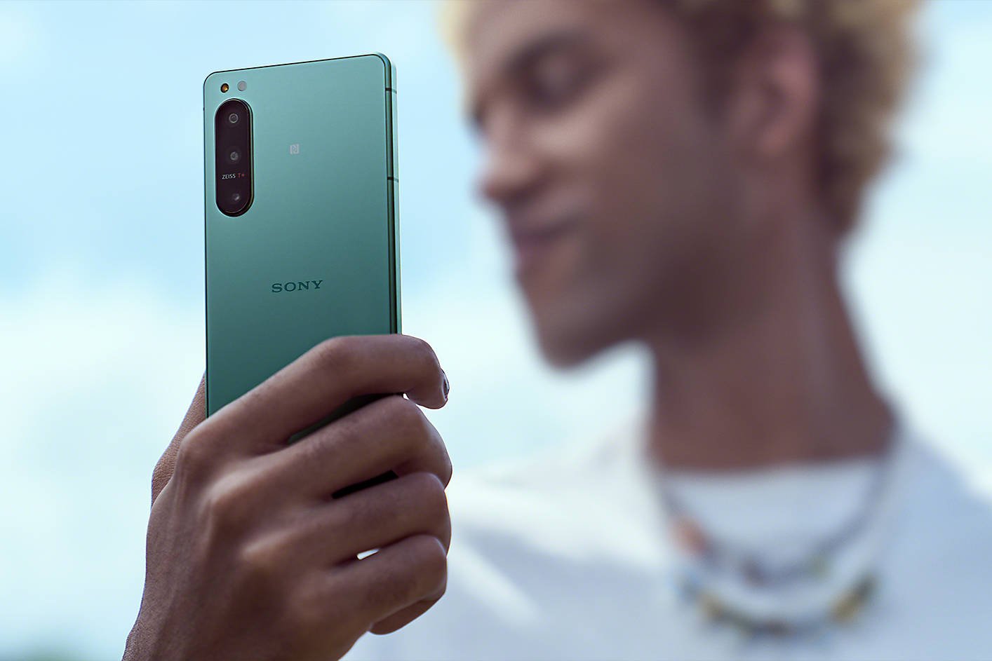 A man holding up an Xperia 5 IV in green