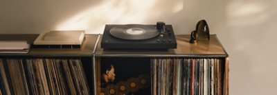 PS-LX5BT on a shelf with vinyl records, books, and decorative items