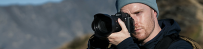 Imagen de uso de un fotógrafo sosteniendo la α7R VI en un entorno al aire libre.